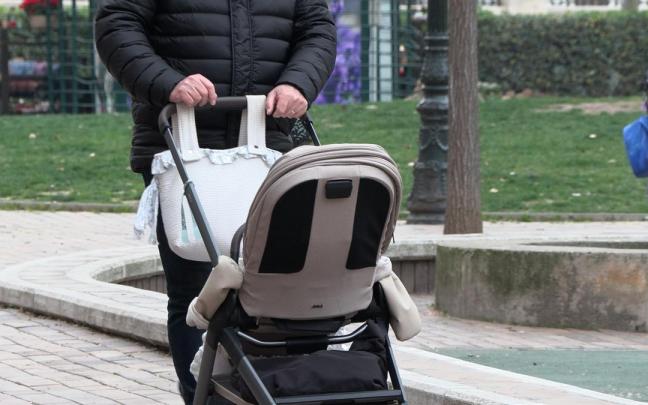 Un hombre empuja un carrito de bebé.