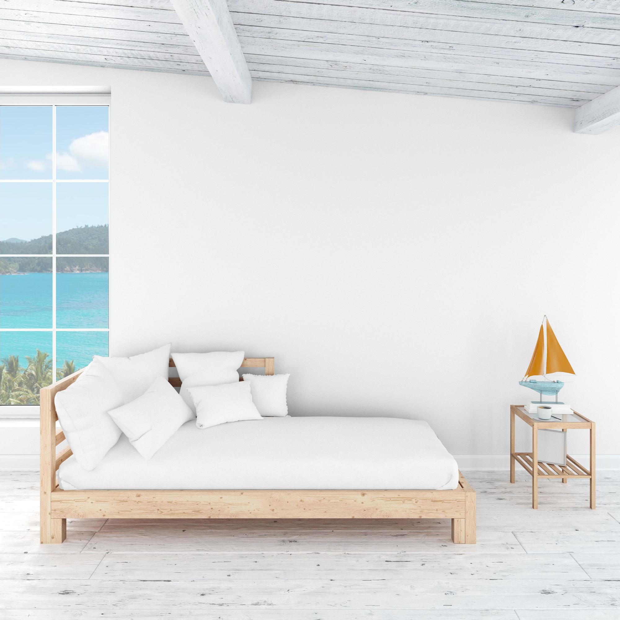 Habitación en color blanco con la cama y la mesilla en madera clara.