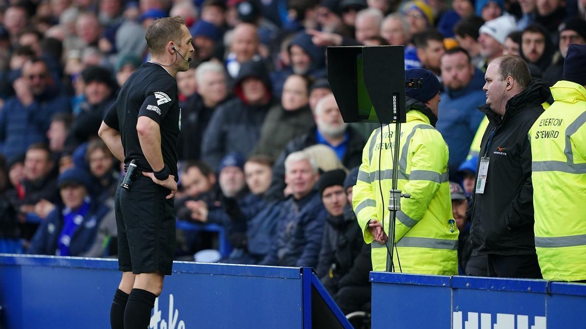 Un árbitro consulta una jugada dudosa en un partido de la Premier League.