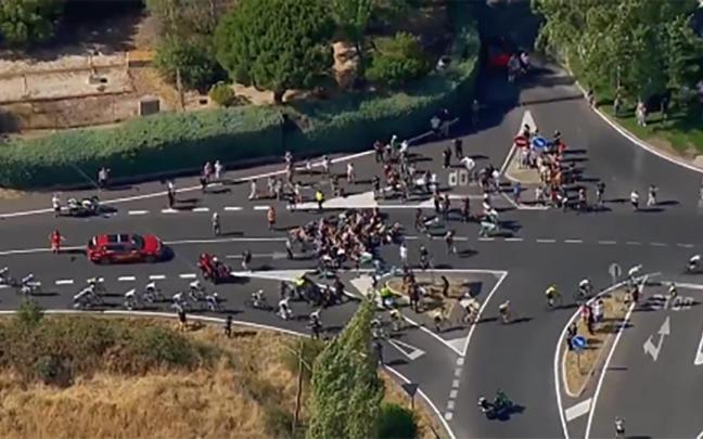 Momento en el que los ciclistas esquivan a los manifestantes que invadían la calzada.