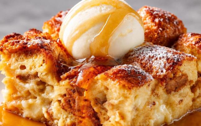 Pudin de pan acompañado de helado de vainilla y un hilo de caramelo.