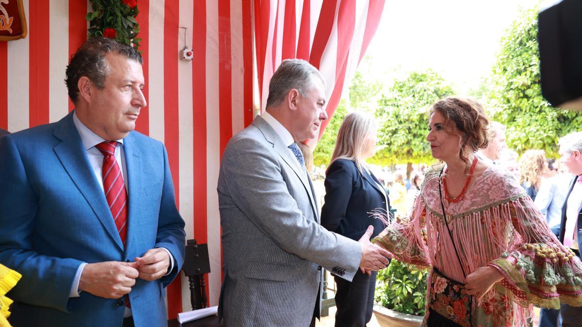 María Jesús Montero, saluda al alcalde de Sevilla, José Luis Sanz, junto al presidente de la Diputación Javier Fernández, en la Feria de Abril de Sevilla.