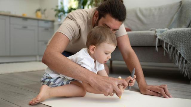Un padre ayuda a su hijo a pintar. / Freepik Un padre ayuda a su hijo a pintar.