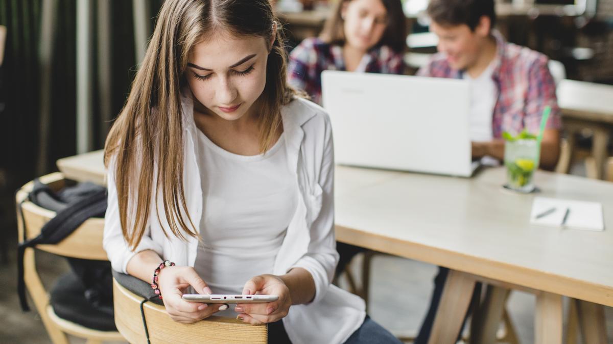 Una chica usa un dispositivo móvil durante una clase escolar.