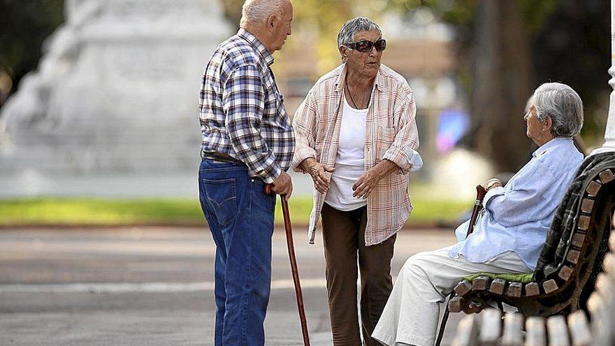 Varias personas mayores charlan en un parque. Foto: Borja Guerrero