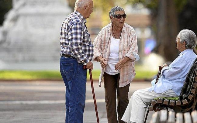 Varias personas mayores charlan en un parque. Foto: Borja Guerrero