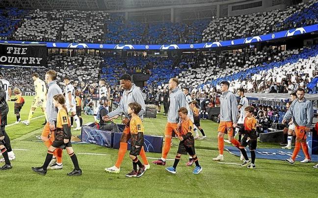 El Inter y la Real saltan al campo con el mosaico de la afición de fondo. / RUBEN PLAZA