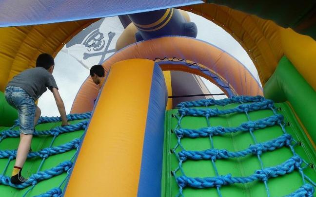 Dos menores juegan en un castillo hinchable.