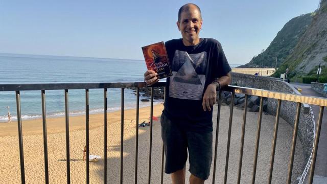 Kepa Iribar posa con su nueva novela 'Odol Ilargiaren Alaba' en la playa de Getaria.