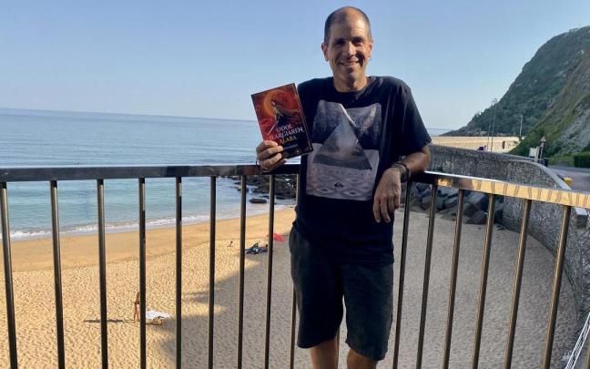 Kepa Iribar posa con su nueva novela 'Odol Ilargiaren Alaba' en la playa de Getaria.