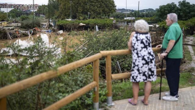 Dos personas observan el barro y el agua embolsada a causa de las lluvias torrenciales, a 4 de octubre de 2026, en Montornès del Vallès, Barcelona.
