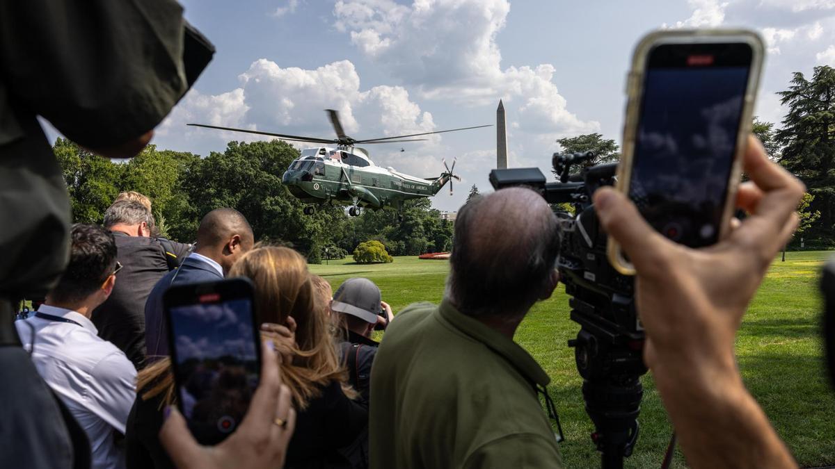 Los periodistas esperan a que el helicóptero de Biden aterrice en la Casa Blanca.