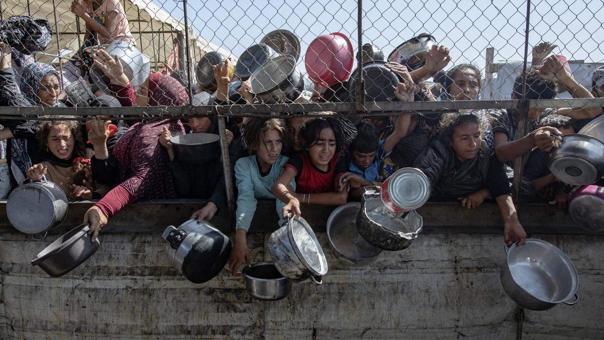 Refugiados palestino de Gaza esperan para recibir comida en uno de los centros de ayuda humanitaria.