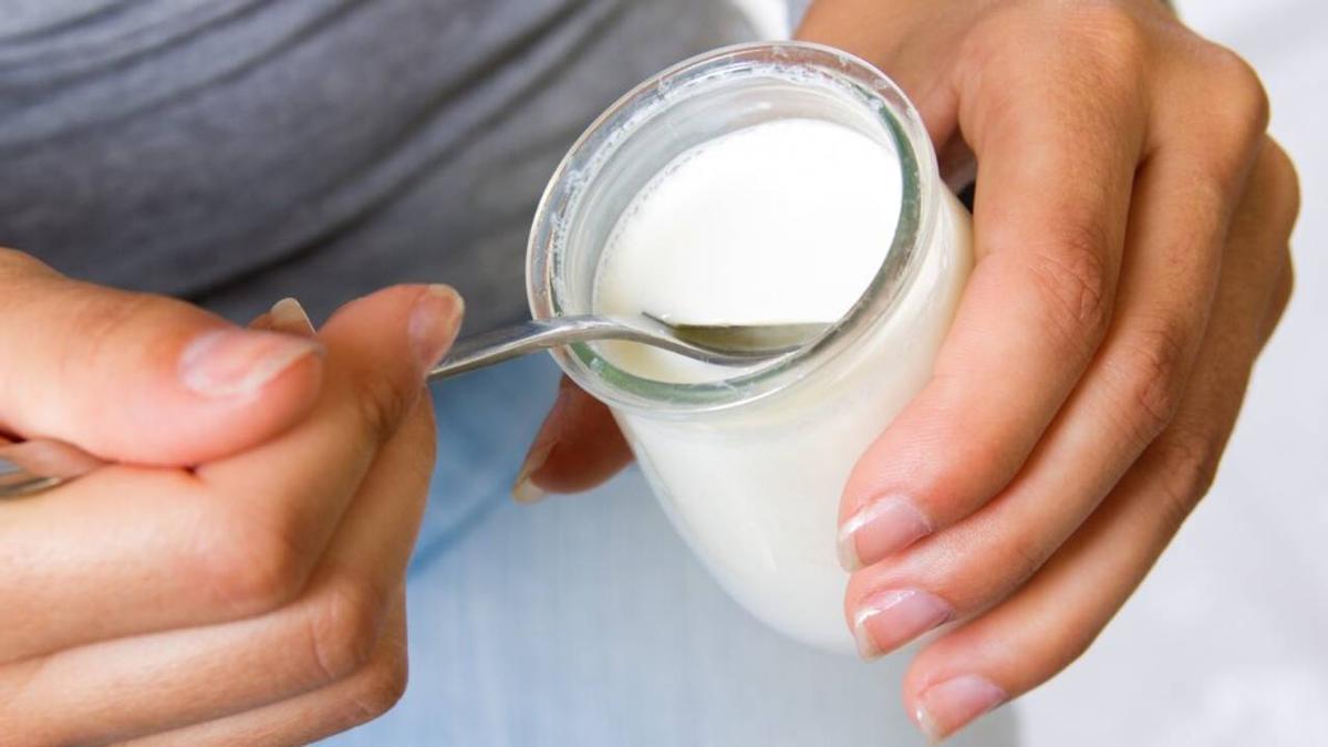 Manos de una chica comiendo un yogur