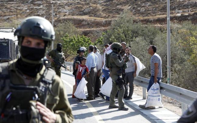 Soldados israelíes impiden a los agricultores palestinos trabajar en la recogida de aceitunas en Cisjordania.