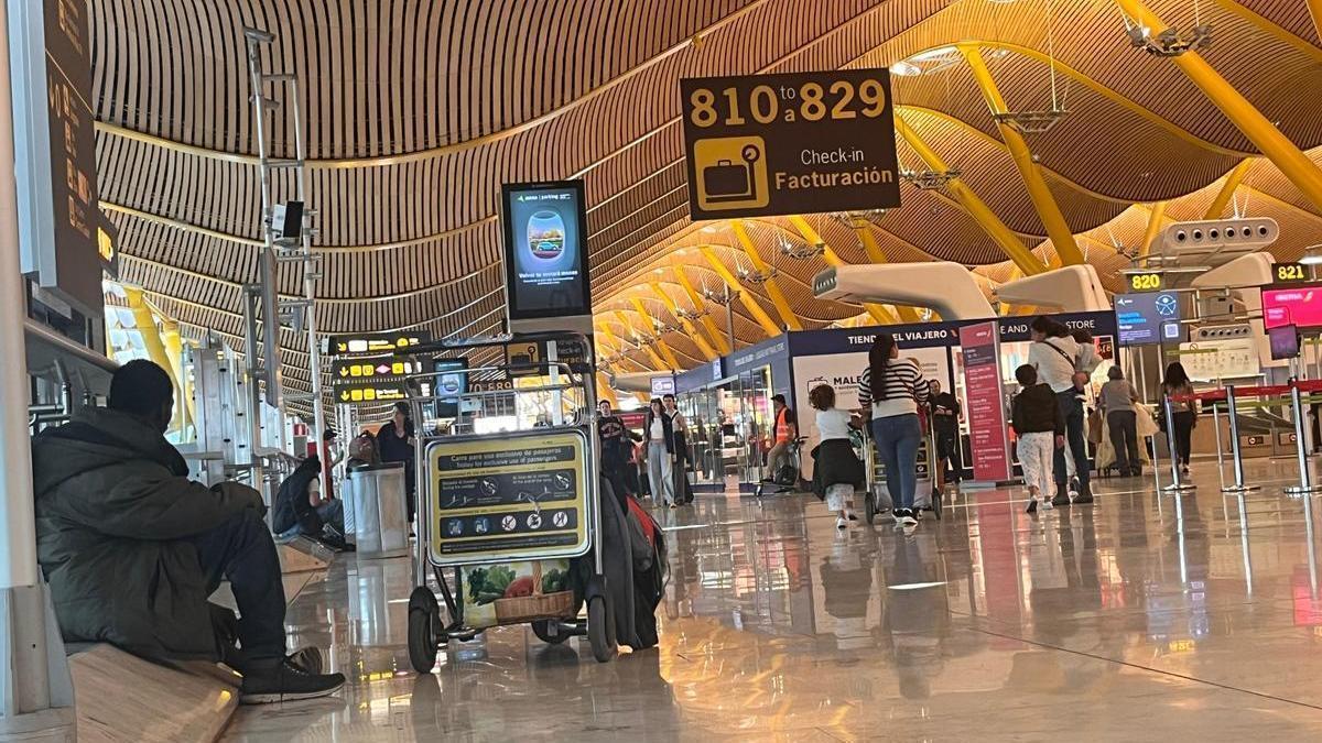 Una persona sin hogar entre los pasajeros de la T4 de Barajas.