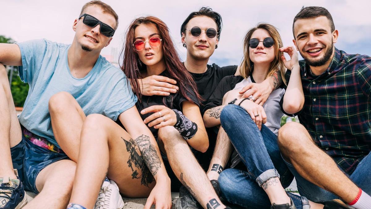 Un grupo de jóvenes luce tatuajes en brazos y piernas.