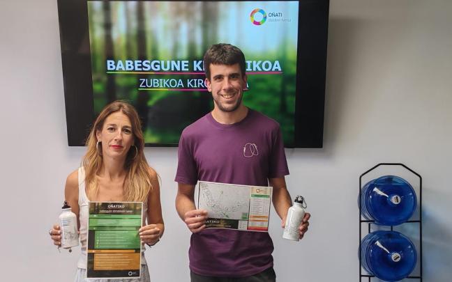 La alcaldesa Izaro Elorza y el edil Iker Oñati muestran el mapa de refugios climáticos y la botella que se reparte en la recepción de Zubikoa, el Servicio de Atención Ciudadana del Ayuntamiento y la Kultur Etxea