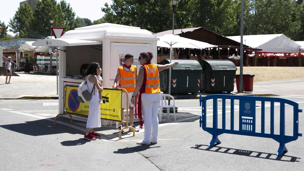 Dos 'naranjitos' dan información a una mujer durante los Sanfermines