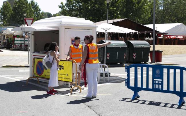 Dos 'naranjitos' dan información a una mujer durante los Sanfermines
