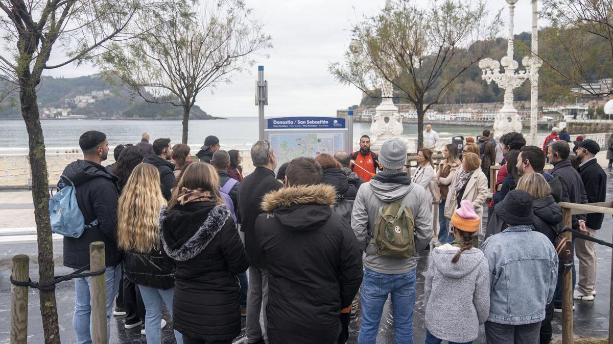 Un grupo de turistas escuchan las explicaciones del guía en el paseo de La Concha / Ruben Plaza