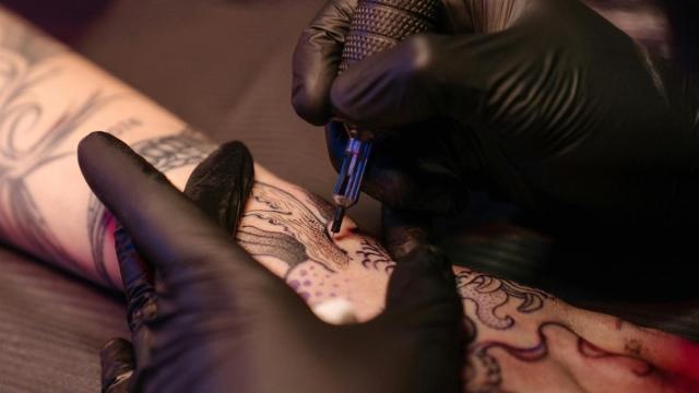 Una persona realiza un tatuaje.