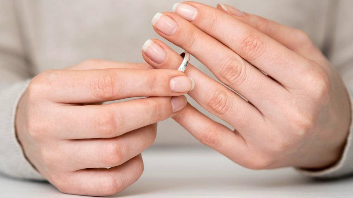 Unas manos sostienen un anillo de plata.