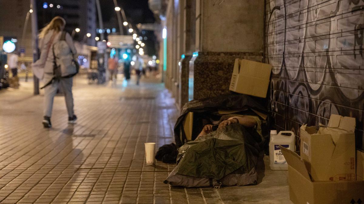 Una persona duerme en la calle.