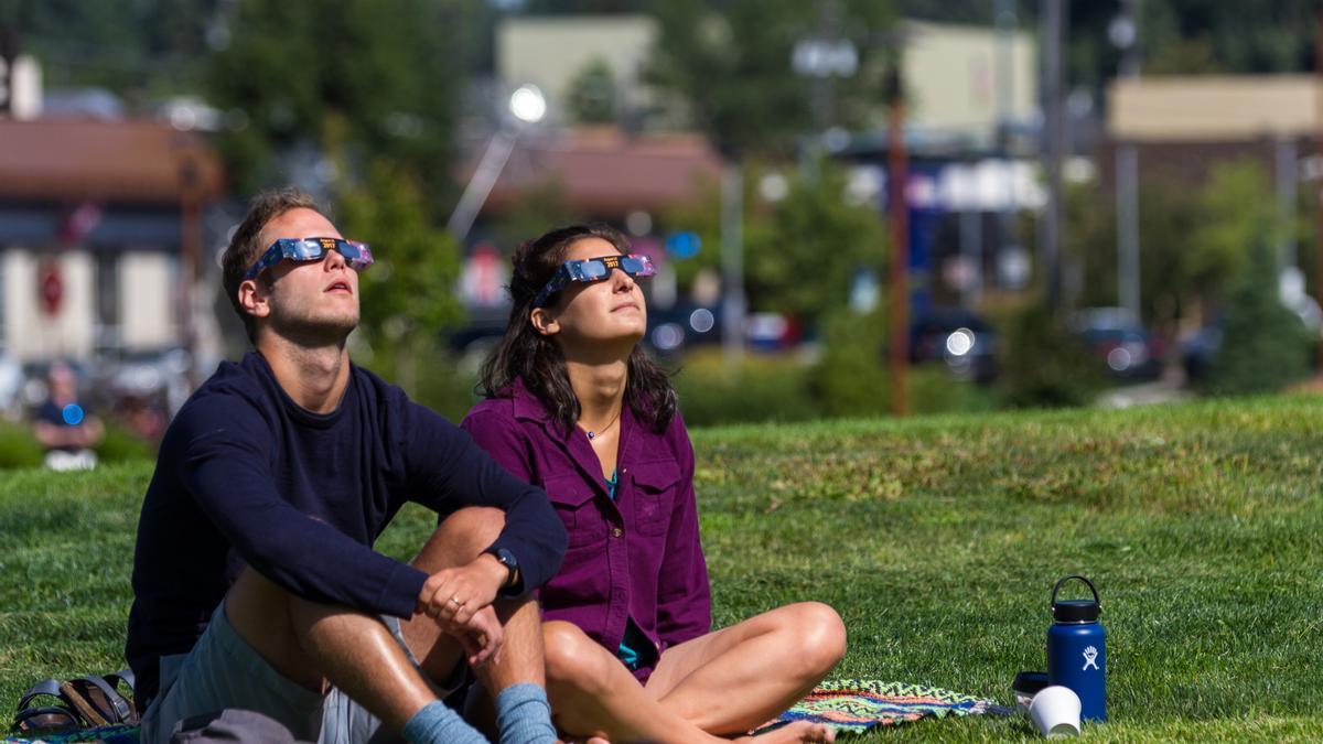 Dos personas observan un eclipse.