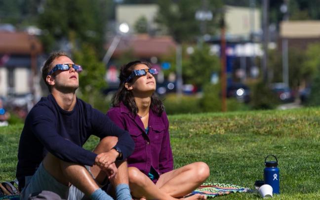 Dos personas observan un eclipse.