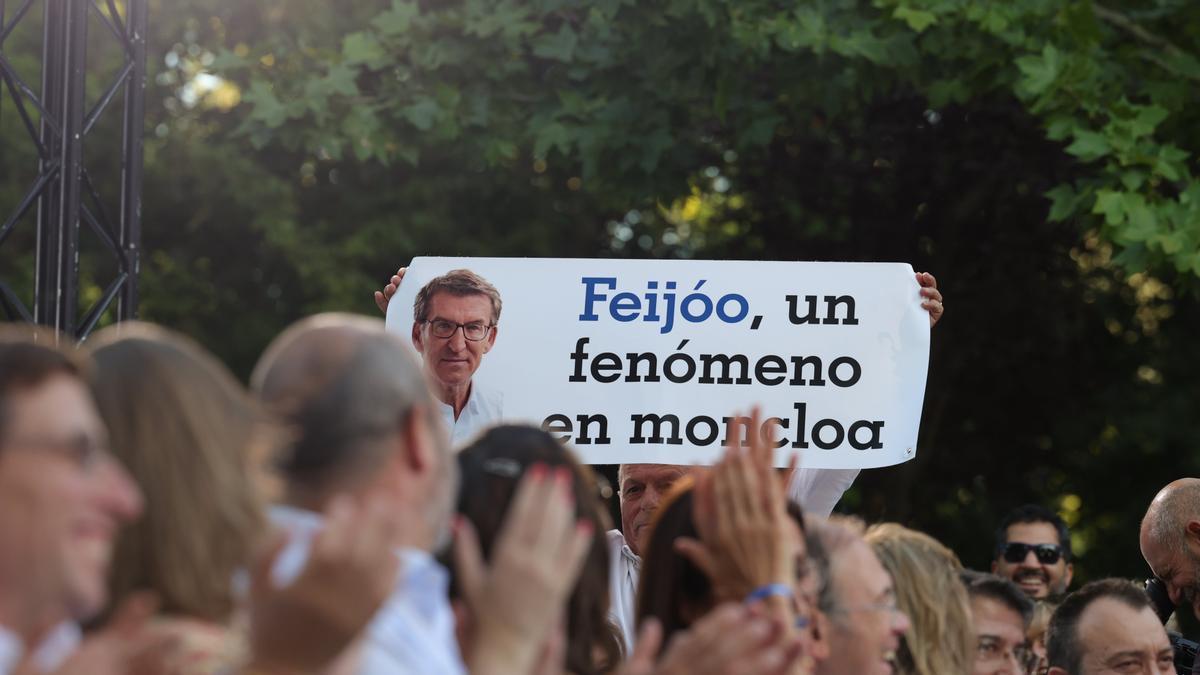 Un asistente al mitin de Feijóo en Madrid sujeta una pancarta de apoyo al líder del Partido Popular.