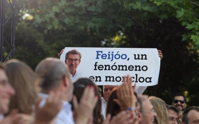 Un asistente al mitin de Feijóo en Madrid sujeta una pancarta de apoyo al líder del Partido Popular.