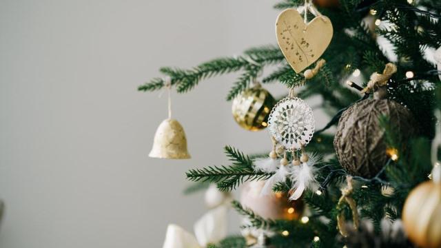 Árbol de Navidad decorado con adornos blancos y dorados de cerca
