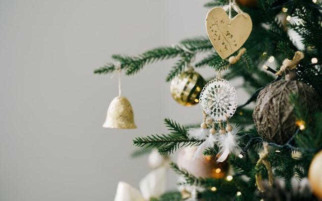 Árbol de Navidad decorado con adornos blancos y dorados de cerca