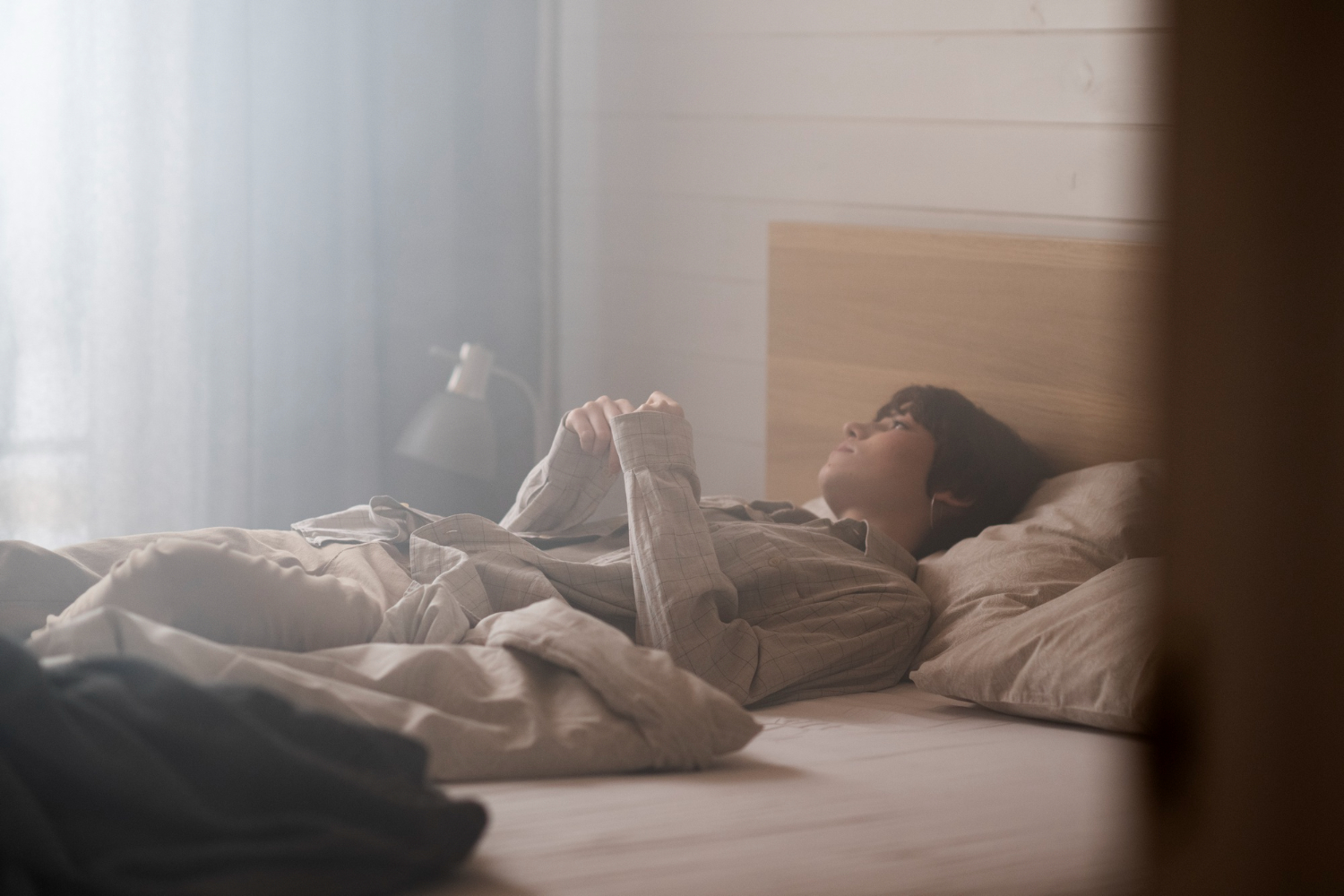 Una persona tumbada en una cama con los ojos abiertos. FREEPIK