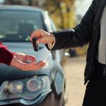 Dos personas se pasan la llave de un coche.