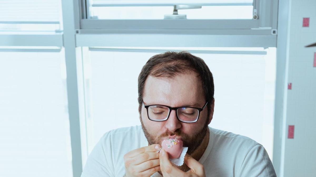 Un hombre no puede resistirse ante una mesa llena de dulces.