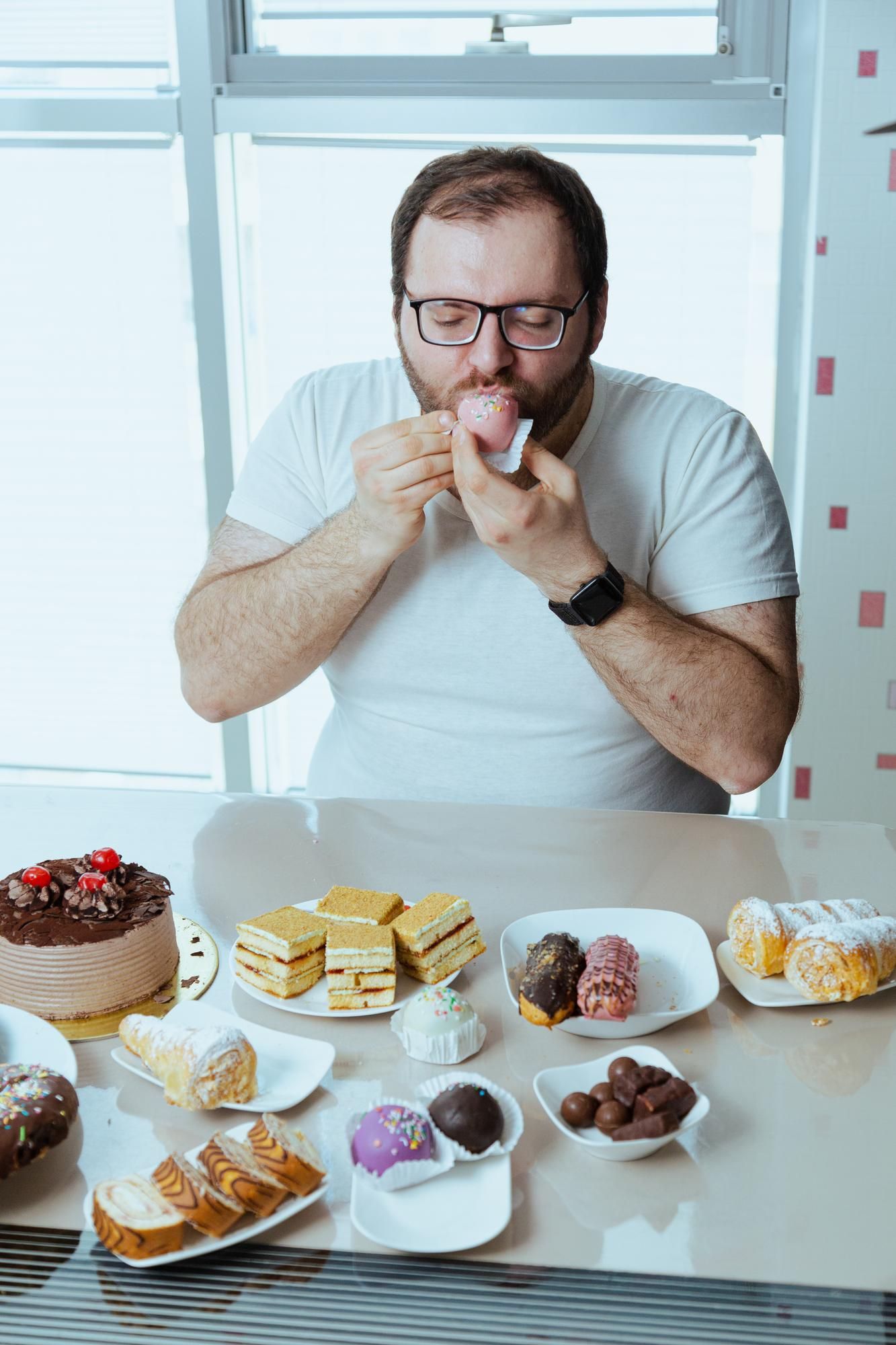 Un hombre no puede resistirse ante una mesa llena de dulces.