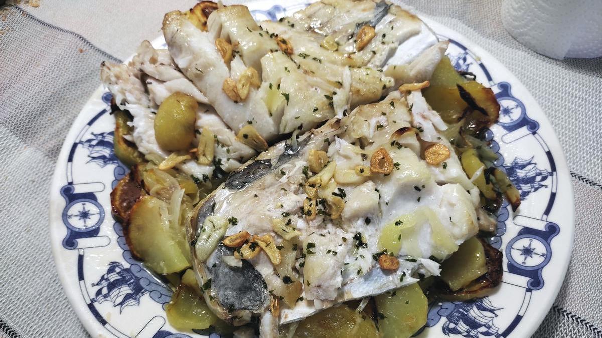 Una fuente con bacalao al horno con patatas.