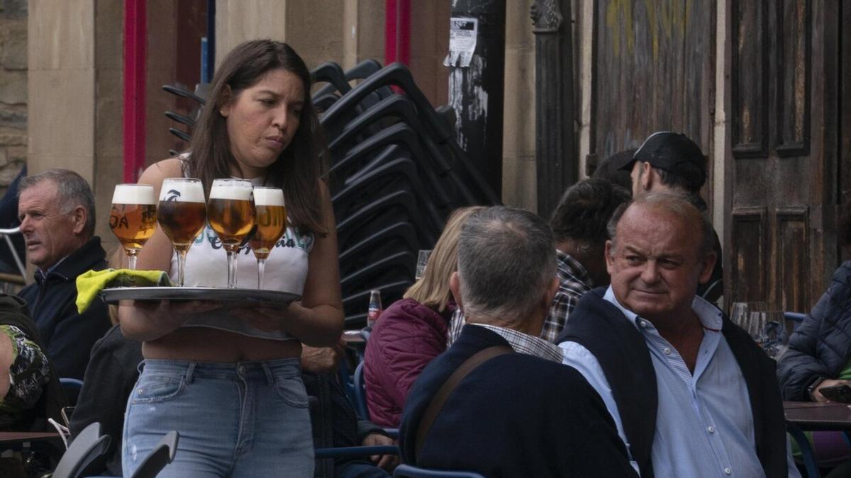 Varias personas en la terraza de un bar.