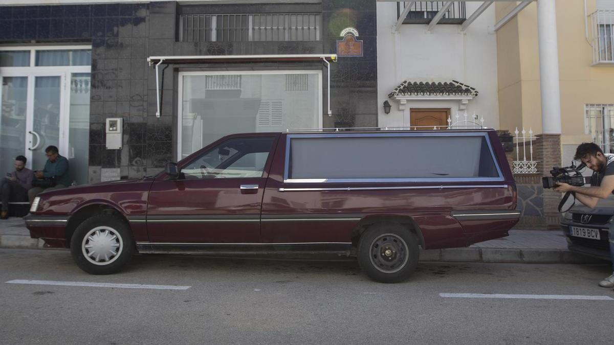 Un coche fúnebre aparcado en medio de la calle.
