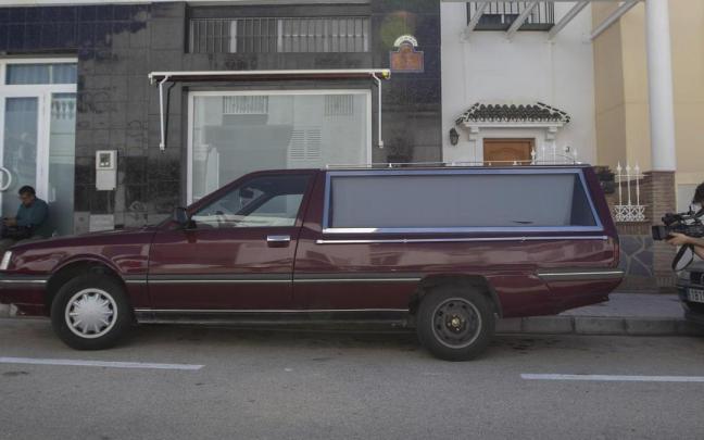 Un coche fúnebre aparcado en medio de la calle.