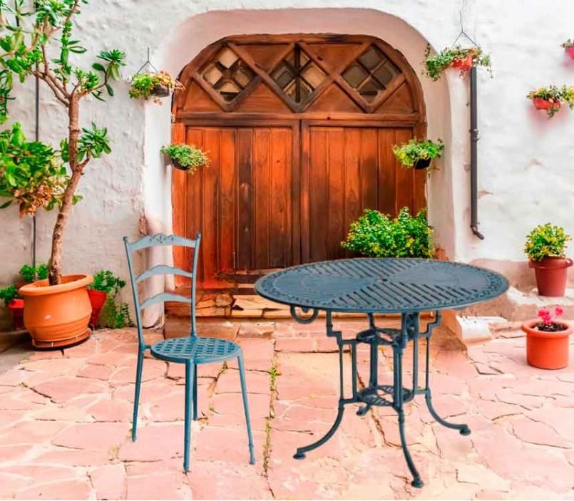 Mesa y silla de hierro forjado en color gris azulado.