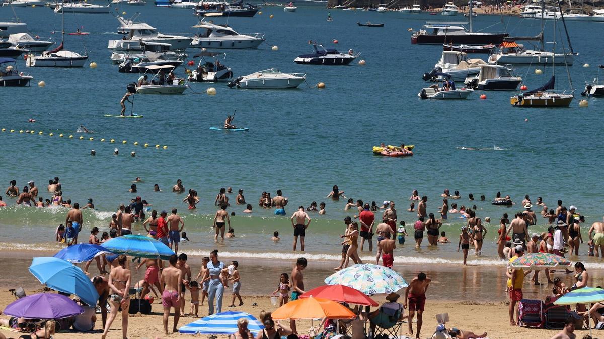 Decenas de personas tratan de sofocar el calor en Donostia bañándose en el mar.