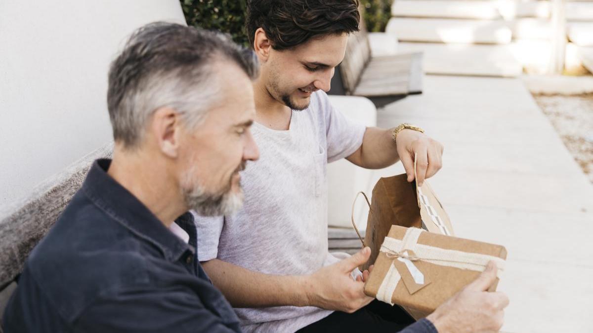 Hombre entrega un regalo a su hijo