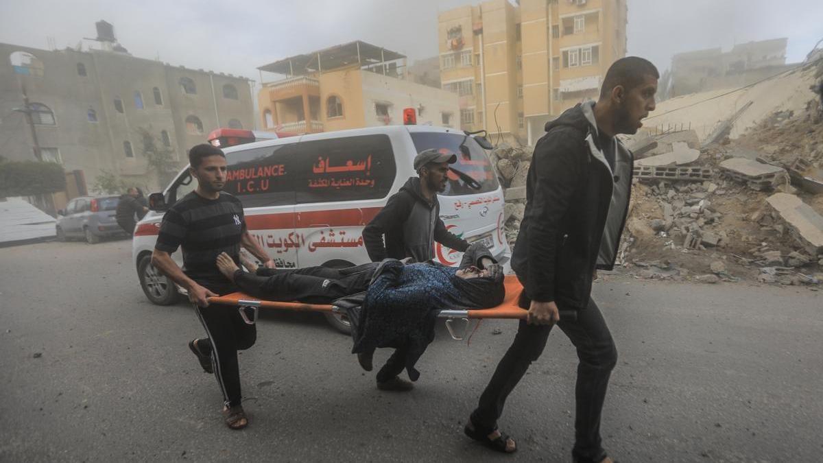 Tres palestinos trasladan a una mujer herida en un ataque israelí.