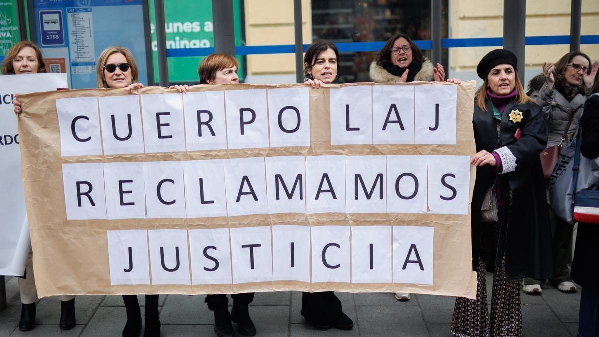 Varias mujeres sujetan una pancarta de 'Cuerpo Laj, reclamamos justicia' ante la sede donde se reúnen el comité de huelga de los Letrados de Justicia y el Ministerio.