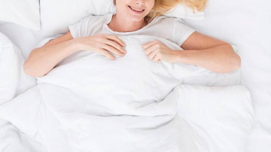 Mujer sonriente descansando en la cama