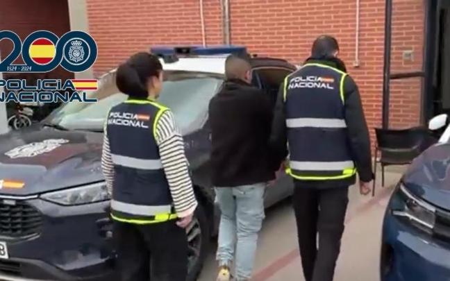 Dos agentes de Policía Nacional custodian al detenido por, presuntamente, encargar el asesinato de una persona a la mara Salvatrucha MS 13,