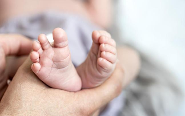 Los pies del bebé recién nacido en manos de mamá. Los pies del bebé recién nacido en manos de mamá.
